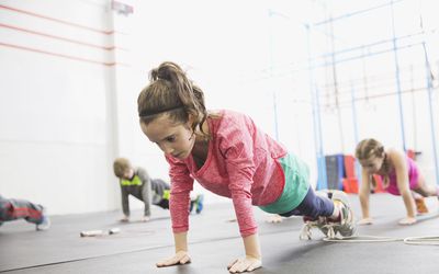 儿童力量训练-女孩在健身房保持平板支撑的位置