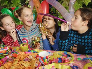 四个孩子(9-11岁)在户外用吹风机参加生日聚会