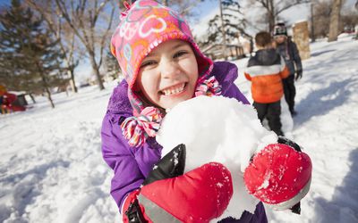 Snow play ideas - girl holding snowball outdoors