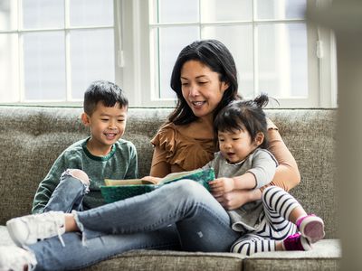 A mom reading to her kids on the couch