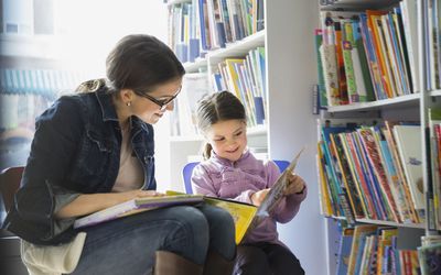 woman and girl reading at library