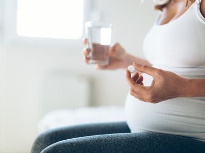 pregnany woman with glass of water and medicine