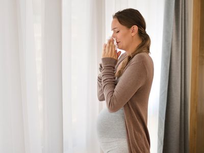 Pregnant person blowing their nose