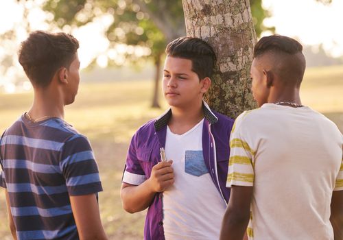 three teen boys discussing vaping