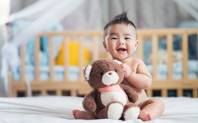 baby holding teddy bear