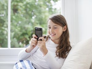 女孩(10-11)在手机上发短信