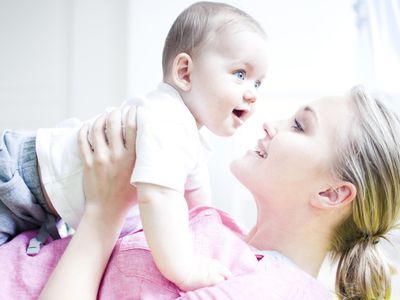 Teenage girl holding baby boy, close up.