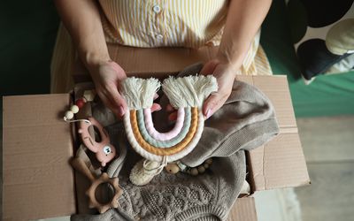 Young pregnant woman with parcel with things for newborn