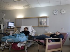 pregnant woman in hospital bed and man sleeping in recliner