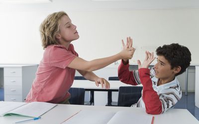学校男生(10-13岁)在教室里打架，一个男生打另一个，欺负人