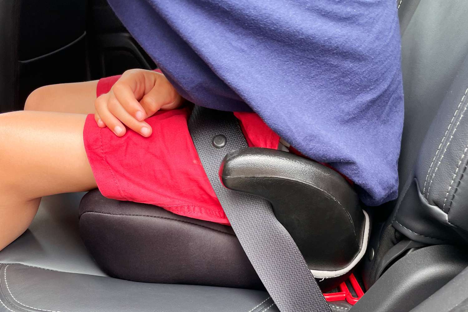 A child sitting in the Chicco KidFit Zip Air Plus 2-in-1 Belt-Positioning Booster Car Seat