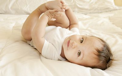 9个月大的男婴躺着母乳喂养从出生到一岁的阶段
