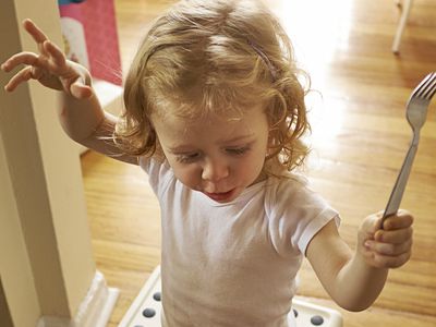 Young girl playing with fork