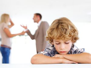 Young boy listening to his parents fighting