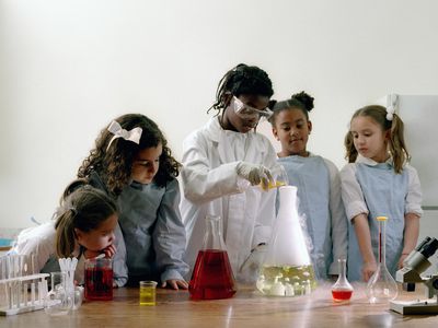 Group of girls (8-10) in science lab working on experiment.