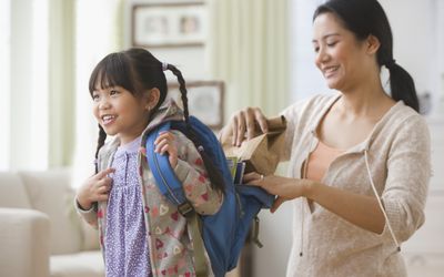 mother helping daughter get ready for school