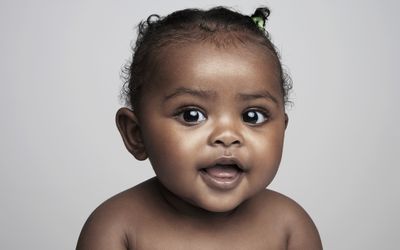 Baby girl (6-9 months) smiling, portrait - stock photo