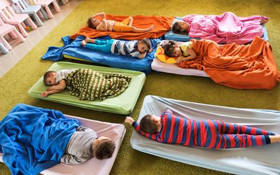 Preschoolers nap on cots