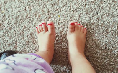 蹒跚学步的小女孩的彩绘脚趾