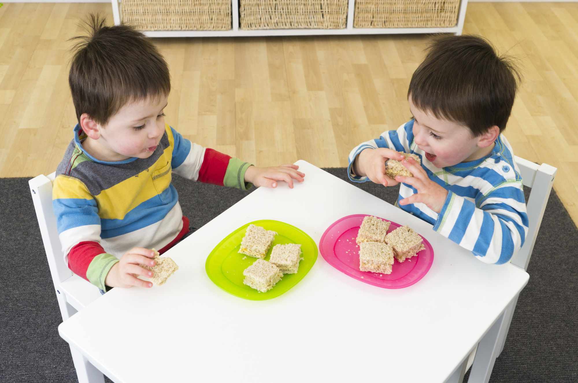 Twin boys eating sandiwches