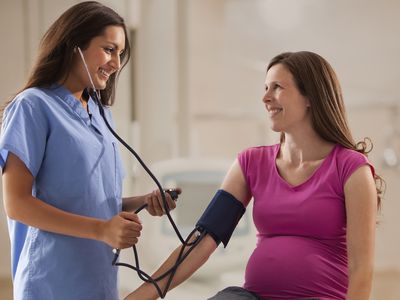 A pregnant woman has her blood pressure checked.