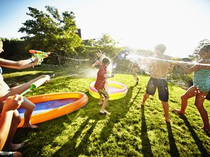 Kids having fun with squirt guns in a backyard