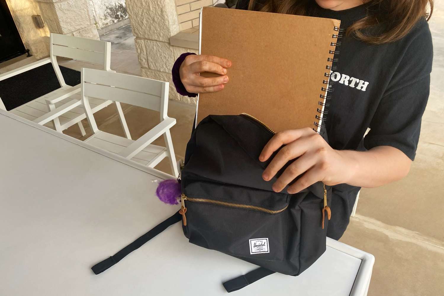 A student using the Herschel Supply Settlement Backpack