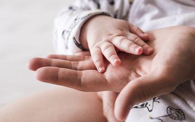 Baby hand in adult hand