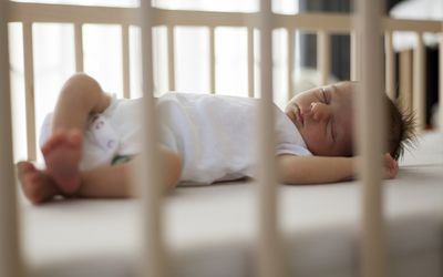 infant sleeping in a crib