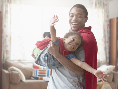 father and son playing dress up in living room