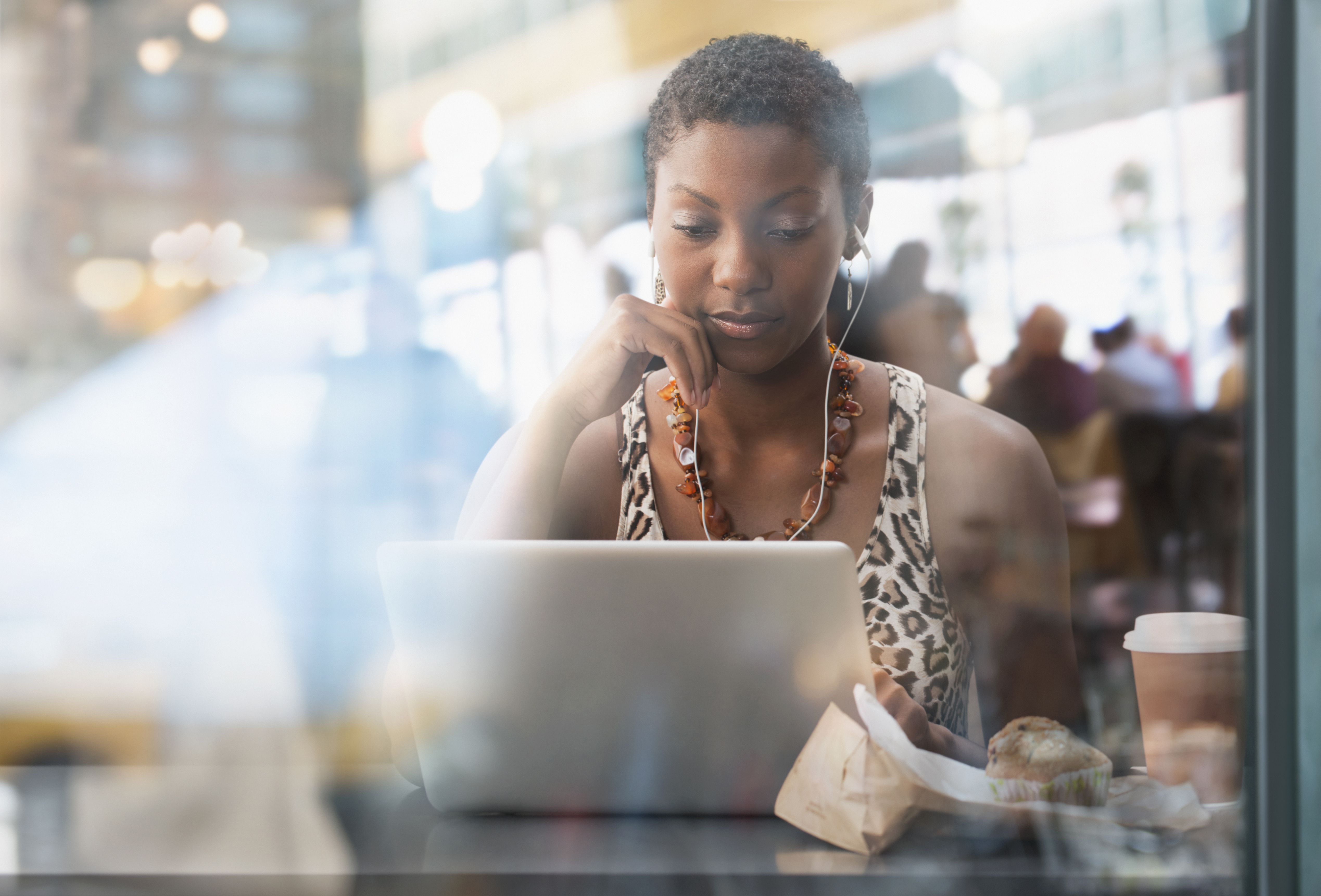 非洲裔美国女性在咖啡馆使用笔记本电脑，试图对不孕的朋友保持敏感