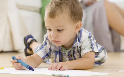 Baby coloring on floor