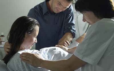 助产士和丈夫支持在医院分娩的孕妇