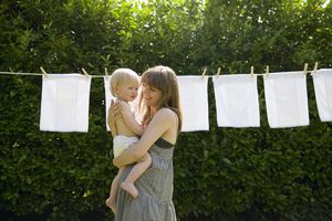 母亲和婴儿在晾衣绳上的尿布前