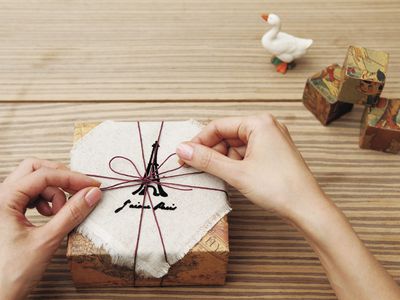 a woman tying a bow on a beautifully wrapped gift