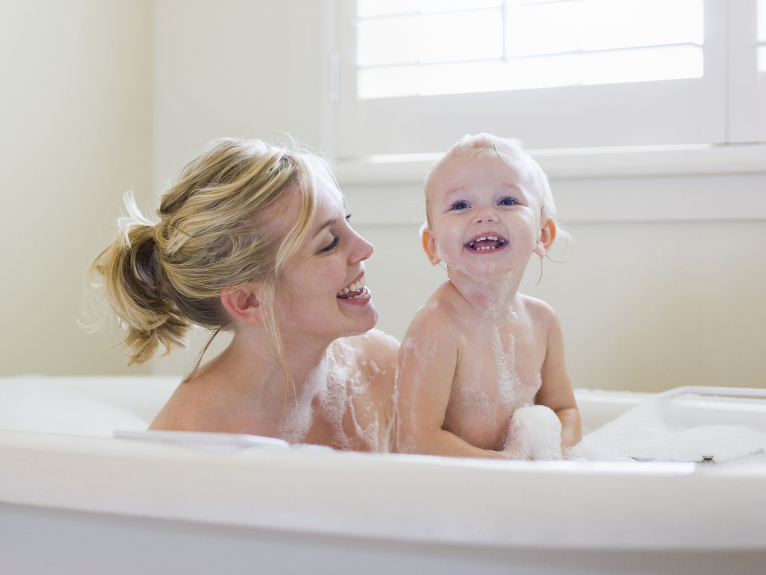 Mother and baby take a bubble bath