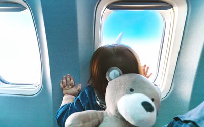 Toddler looking out airplane window
