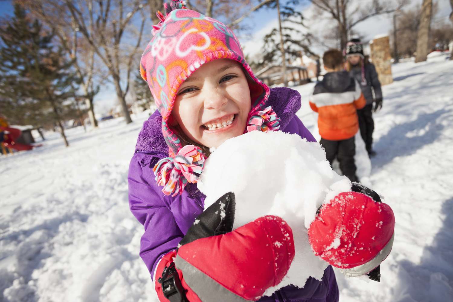 Snow play ideas - girl holding snowball outdoors