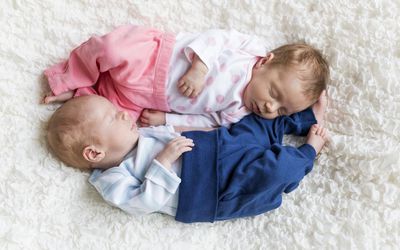 刚出生的双胞胎睡在白色毯子上