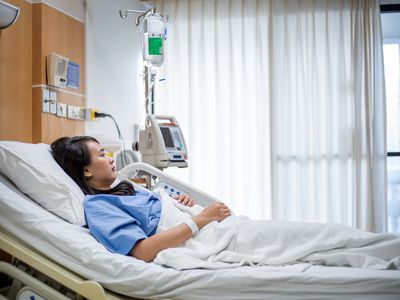 Young woman awake in a hospital bed