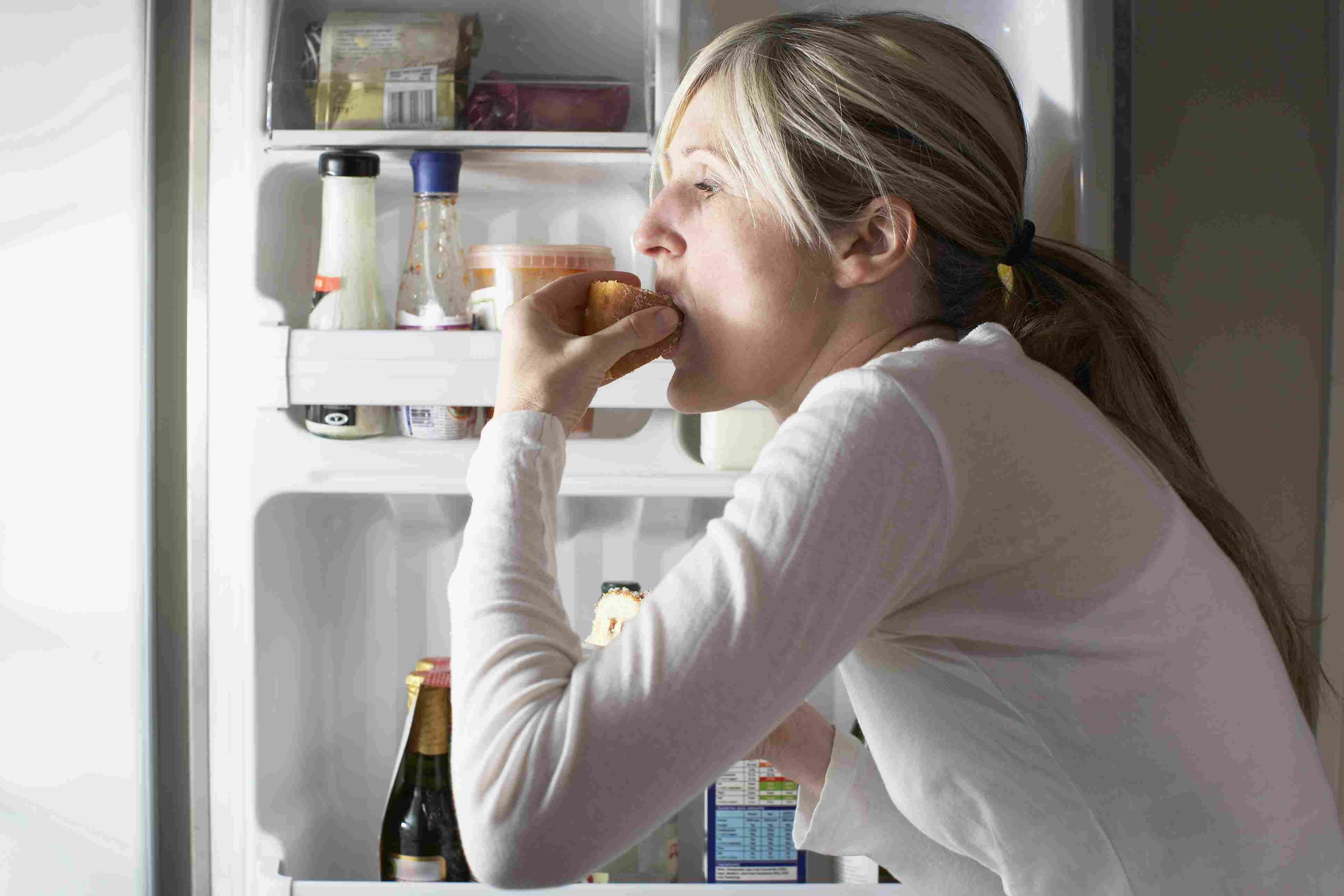 女人从冰箱里拿食物吃