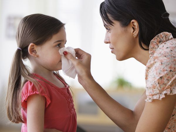 parent helping a child blow their nose