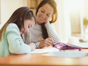 Mother watching daughter do homework