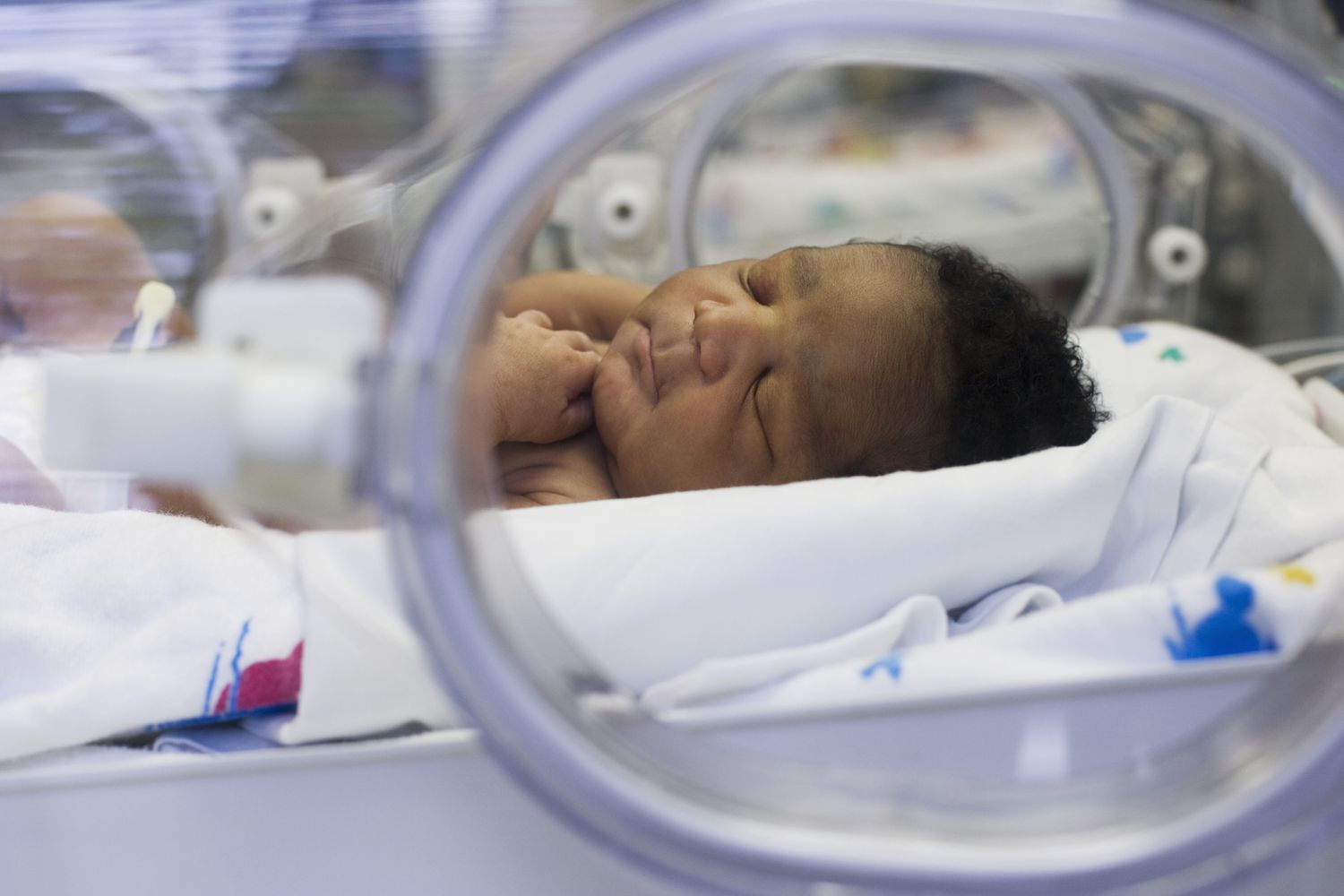 baby boy laying in hospital incubator