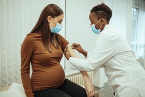 孕妇准备通过手臂消毒接种疫苗。