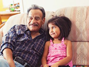 Grandfather and Granddaughter Laughing on Couch