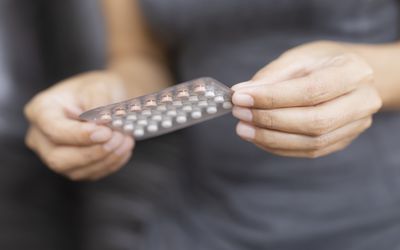 妇女拿着水泡包装的避孕药