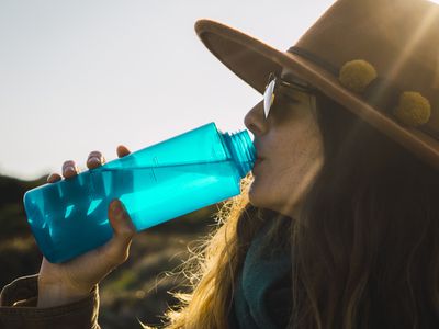 Woman on a hiking trip drinking from water bottle