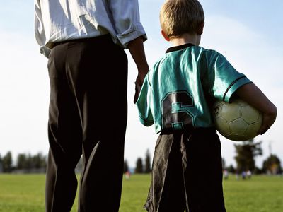 Father and son at soccer field with ball