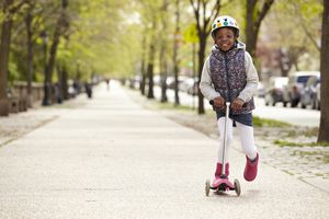 年轻的非裔美国女孩骑着滑板车